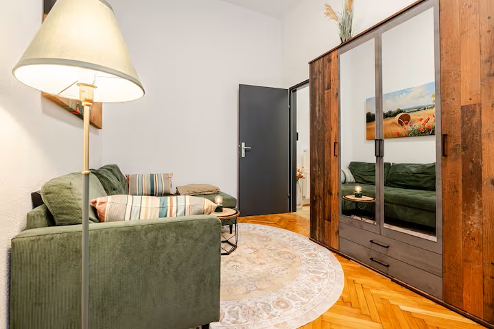 Sitzecke mit Sofa, Stehlampe und großem Kleiderschrank